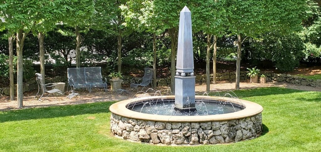 A fountain in a park surrounds by rocks